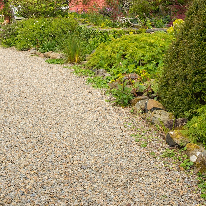 garden with a pebble path and lush shrubs and plants featuring the ArmorFilter
