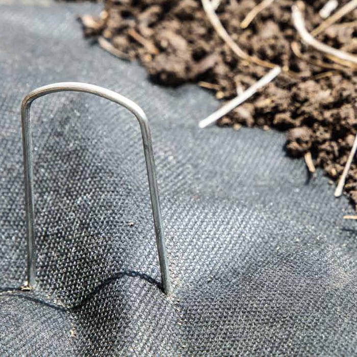 Lanscape pins holding down a weed prevention fabric